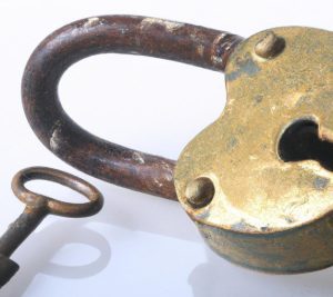 an old rusted warded lock with a key