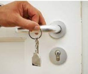 door knob with a residential lock and keys held by a hand