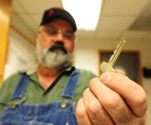 A man holding a key symbolizing locksmith training