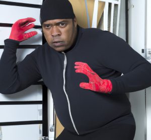 burglar getting caught red handed shown symbolically with picture of a burglar with red hands