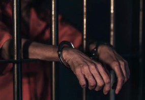 a man handcuffed in jail 